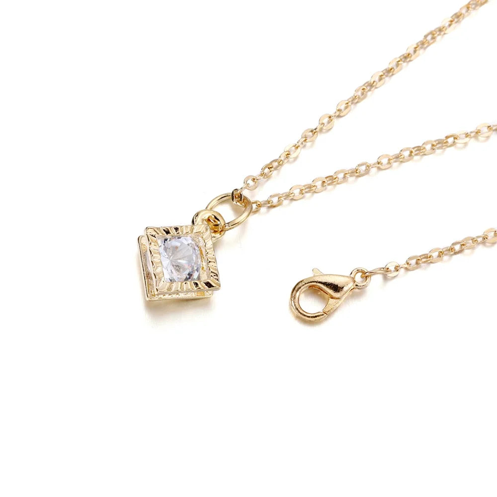 Gold-toned chain necklace with a square rhinestone charm and a jump ring clasp.