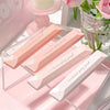 A pink box displays four clear adhesive dot tape glue rollers arranged diagonally on a white surface.