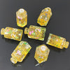 A collection of seven floral resin potion bottle polyhedral dice set in various sizes and colors.