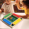 A wooden dice game set with colored wooden blocks and dice on a green board being played by children.