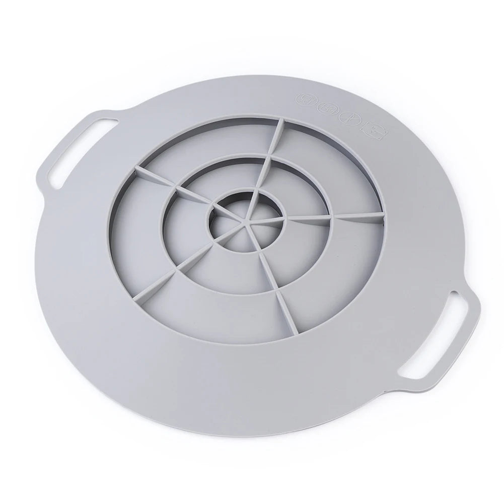 A round, light gray silicone spill stopper lid with a handle for pots and pans.