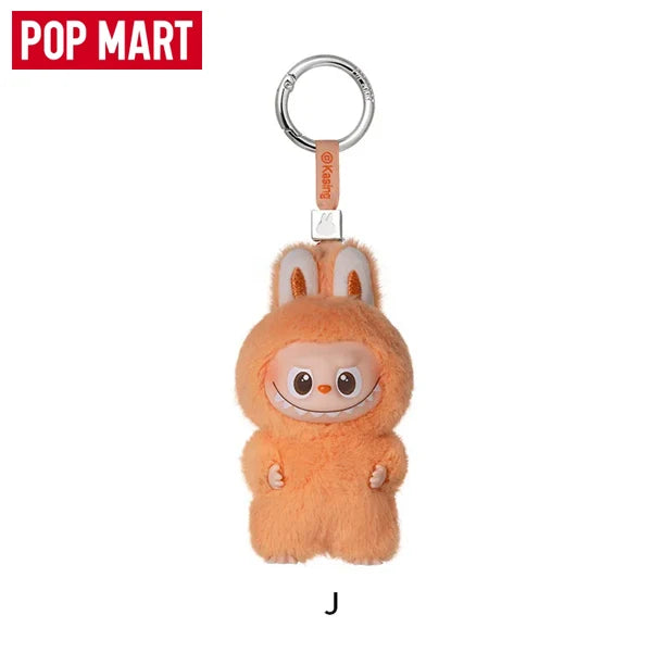 An orange Labubu V4 pin keychain plush doll with large ears and a smiling face.