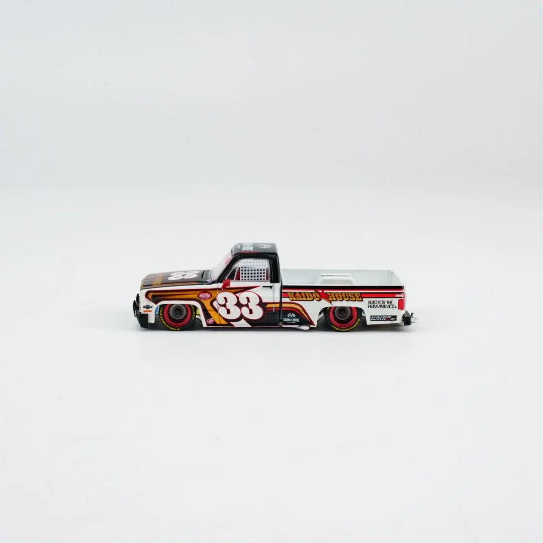 A die-cast model of a Chevrolet Silverado truck in a custom paint scheme with the number 33.