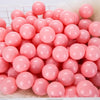 A pile of pink and white plastic play balls for games and ball pits.