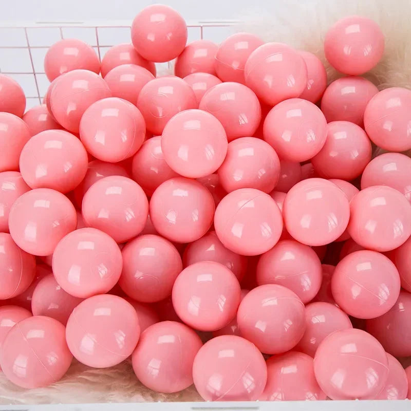 A pile of pink and white plastic play balls for games and ball pits.