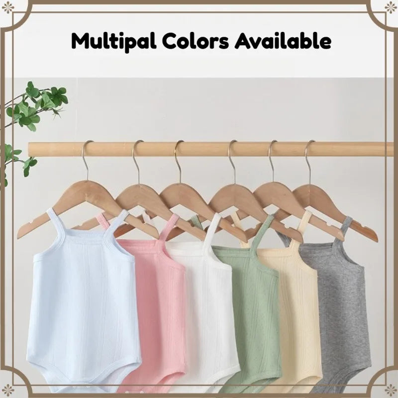 A display of multiple colored lightweight cotton strappy rompers hanging on a wooden rack.