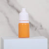 An orange bottle of water marbling paint art kit for kids with a white cap sitting on a white surface.