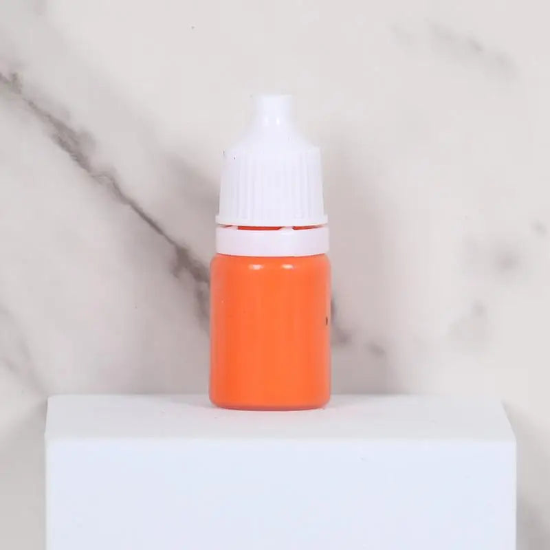 An orange bottle of water marbling paint art kit for kids with a white cap sitting on a white surface.