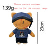 A plush doll resembling a bear with blue ears and a black face, wearing a dark shirt and pants.