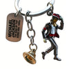 A silver keychain featuring a figure of Michael Jackson and a gold-colored hat.