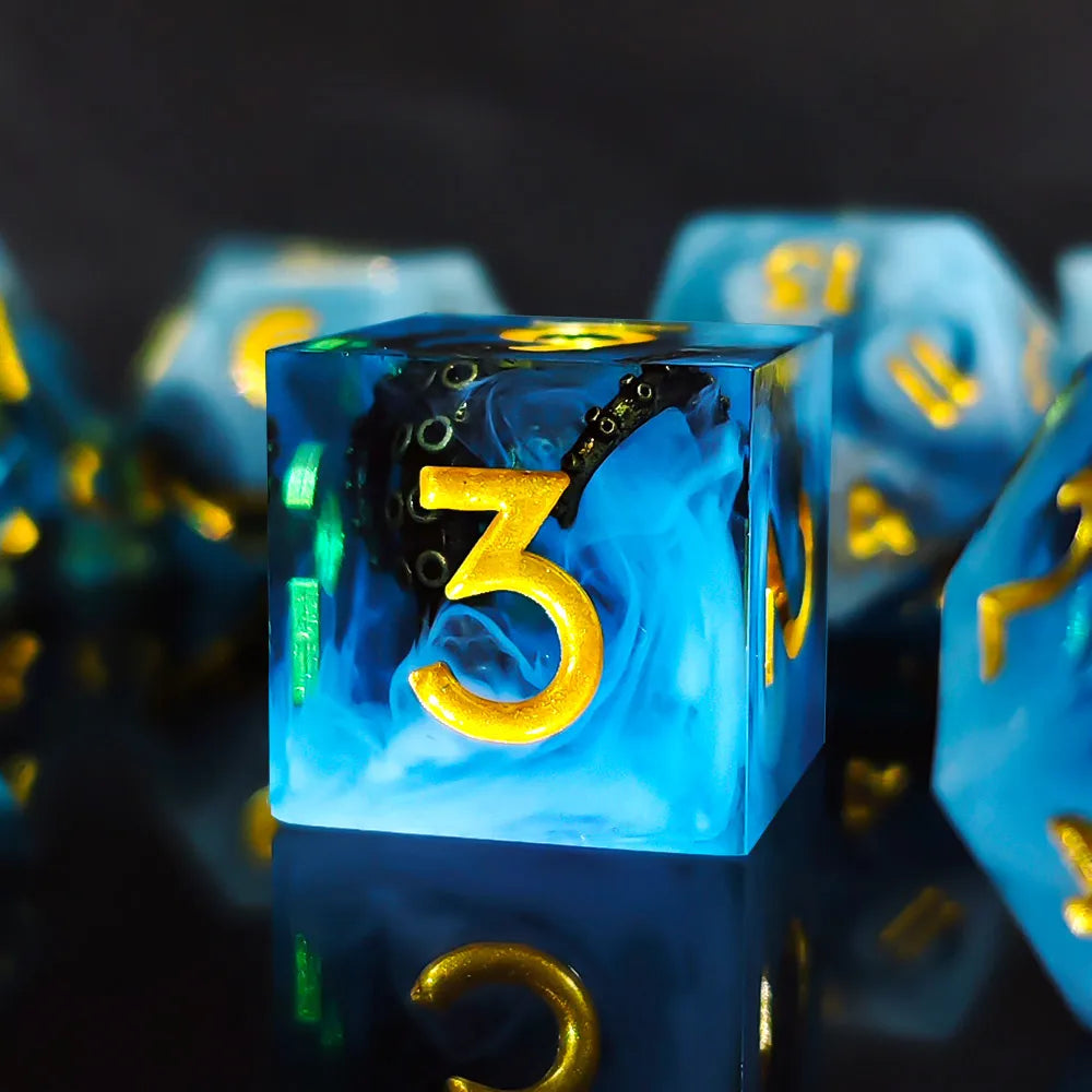 A close-up of a blue resin die showing the number three, reflecting on a dark surface.
