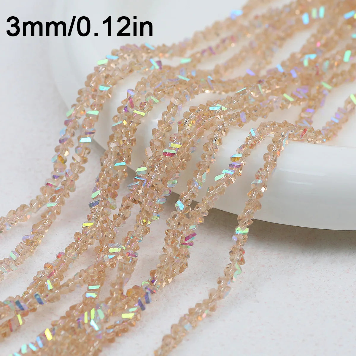 Strands of 3mm crystal triangle beads in a light pink or amber color are displayed on a white surface.