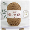 A ball of brown chenille yarn with a white label featuring Chinese characters for knitting and crochet.