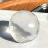 A clear, spherical stress ball with a coconut scent resting on a white plate.