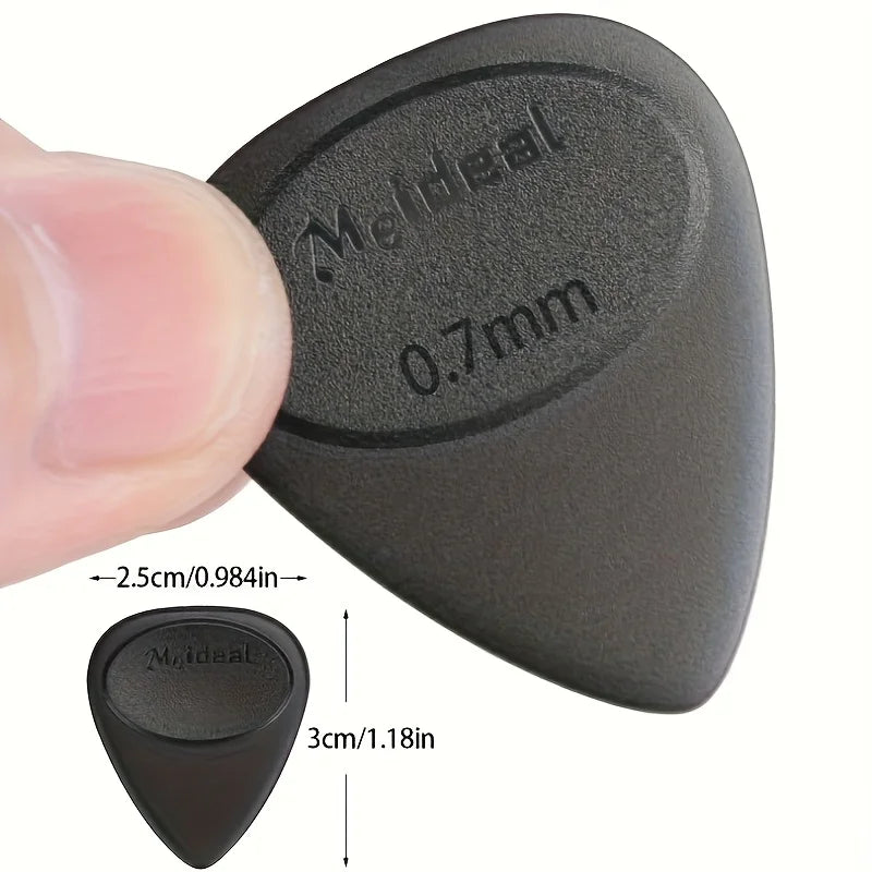 A close-up view of a black guitar pick with an anti-slip grip, showing its size and shape.