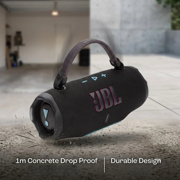 A black portable speaker with a textured finish and a handle is shown on a concrete surface.