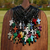 A collection of natural stone cross pendants in various colors and materials displayed on a wooden background.