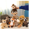 A hand is placing a plush toy of a brown bear onto a white surface, surrounded by various jungle animal stuffed toys.