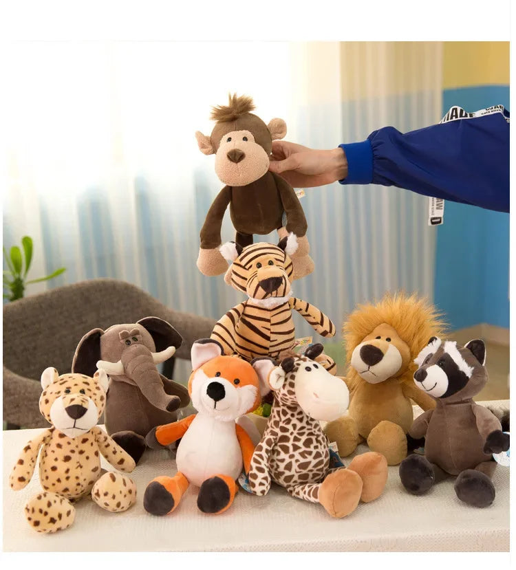 A hand is placing a plush toy of a brown bear onto a white surface, surrounded by various jungle animal stuffed toys.