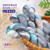 A bundle of hand-dyed grey and blue wool yarn is shown in a basket, ready for knitting or crochet.