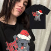 A black t-shirt featuring a graphic design of a dog wearing a Santa hat and text.