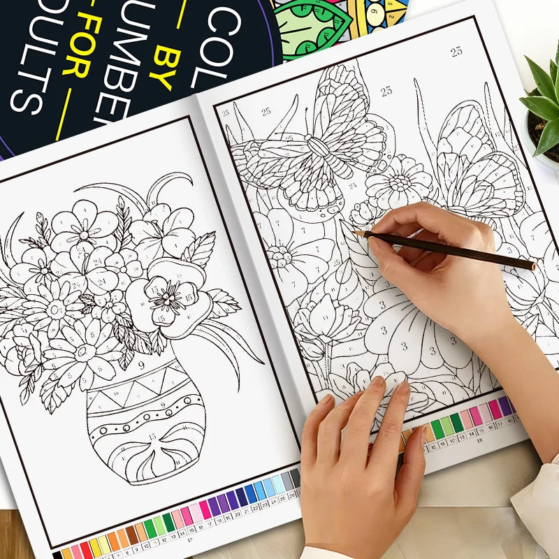 A hand is coloring a page from a color by number book featuring floral and mandala designs.