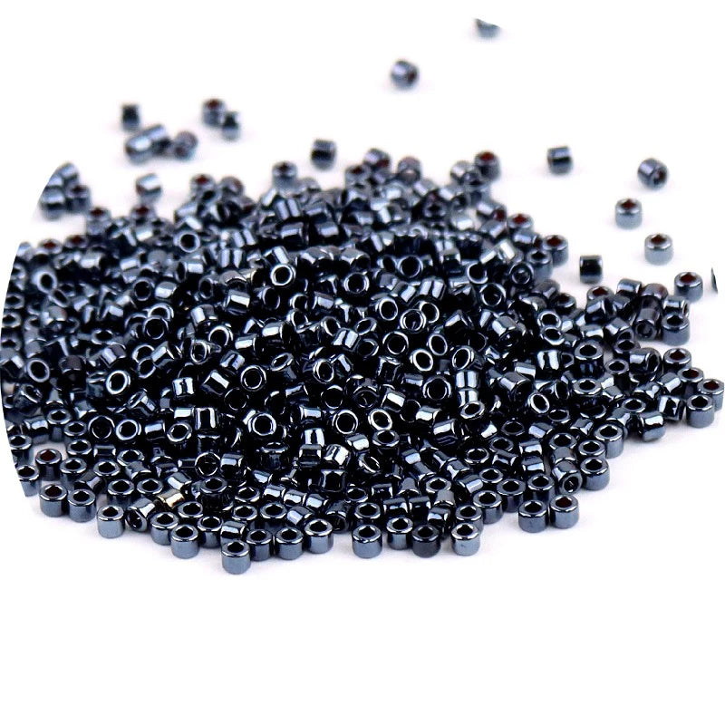 A pile of small, black metallic glass beads for jewelry making.