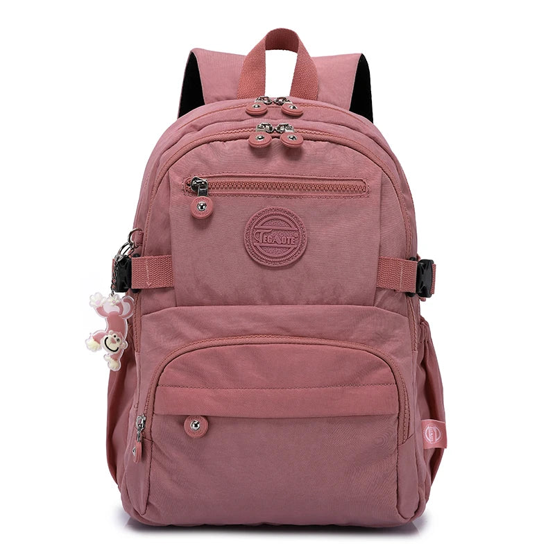 Sac à dos de voyage rose durable avec accents noirs et plusieurs compartiments.