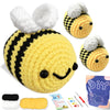 A yellow crocheted bee amigurumi toy with black stripes and large white fuzzy wings, shown next to yarn and tools.