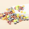 A collection of colorful polymer clay sport ball beads in various shapes and colors arranged on a white surface.