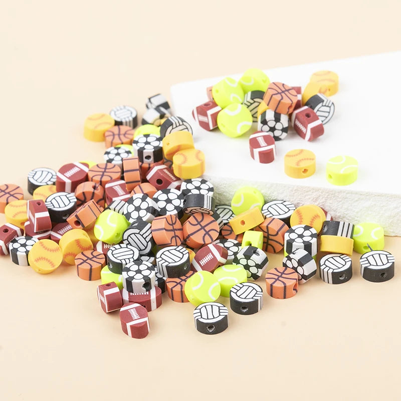 A collection of colorful polymer clay sport ball beads in various shapes and colors arranged on a white surface.