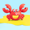 A bright red plastic crab toy with large claws and a yellow background.