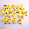 A collection of yellow 3D duck plush hair clips with various decorations arranged on a white background.
