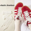 Red Adidas shoes with white elastic silk lace shoelaces on a person's foot.