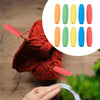 A hand holds a red knitted yarn ball with foam grip sleeves for tools and utensils displayed nearby.