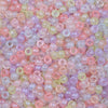 A close-up view of small, round pony beads in various shades of pink, purple, and yellow.