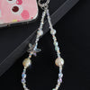 A silver charm featuring a star and various iridescent pearl and crystal beads attached to a bag clip.