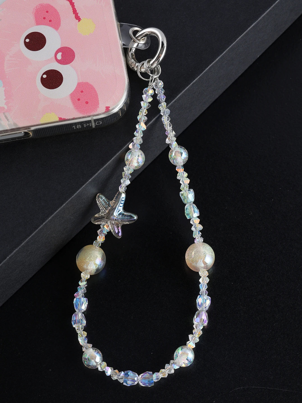 A silver charm featuring a star and various iridescent pearl and crystal beads attached to a bag clip.