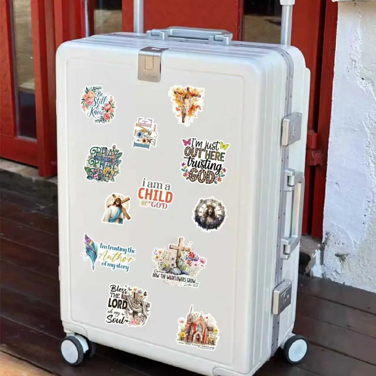 A white rolling suitcase decorated with various inspiring Christian verse stickers for journaling and decor.