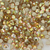 A close-up view of various flatback glass crystal rhinestones in gold and champagne tones.