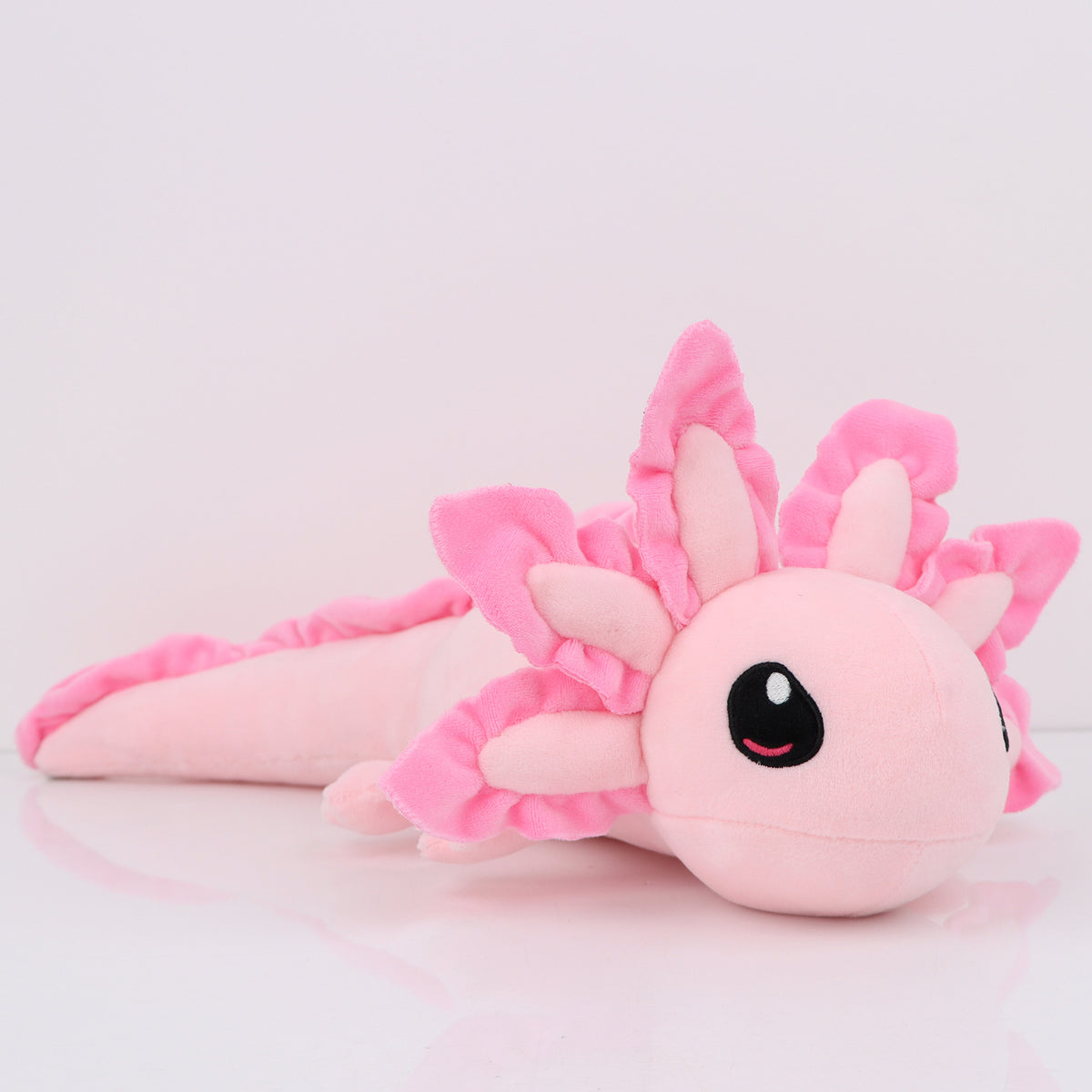 A pink kawaii axolotl plush toy with spiky pink hair and large black eyes.