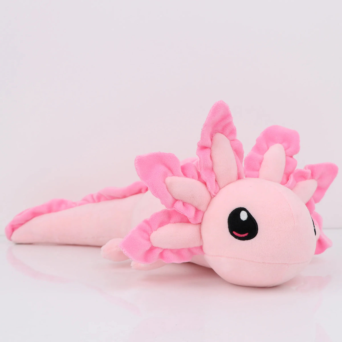 A pink kawaii axolotl plush toy with fluffy pink frills and large black eyes.