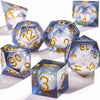 A collection of blue liquid core polyhedral dice with a galaxy finish scattered on a white surface.
