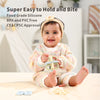 A baby is holding a silicone teether set for babies with various chew toys on a table.