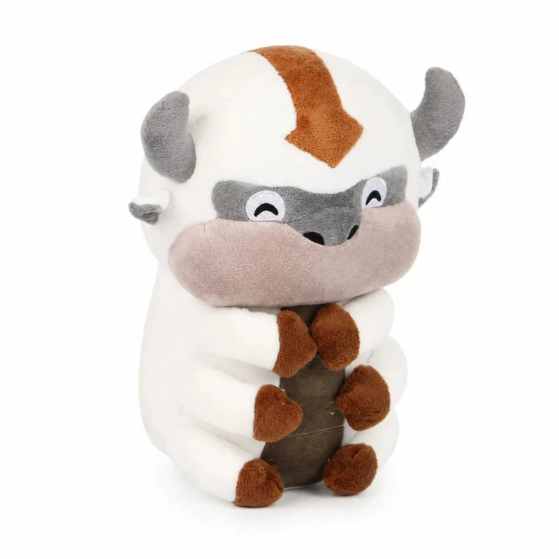 A soft plush doll resembling a stylized bison or horned creature with white, gray, and brown fur patches.