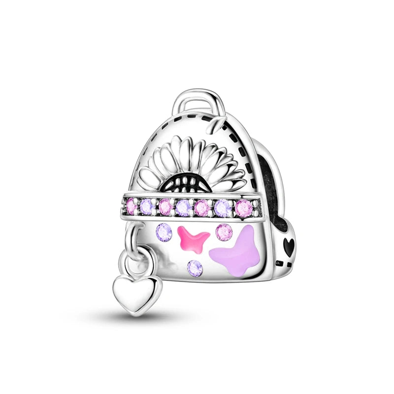 A silver heart charm bead featuring a daisy design and pink zircon accents.