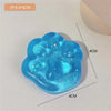 A light blue squishy toy shaped like a cat paw, featuring glitter accents.