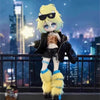 A yellow-haired anime figure wearing sunglasses and a leather jacket stands on a balcony overlooking a city skyline at night.