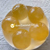 Six round, translucent yellow coconut oil squishy stress relief balls arranged on a white plate.