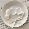White floral lace baby headband displayed on a light background.